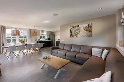 a living room with a brown couch and a table at De Gouden Spar in Noordwijk