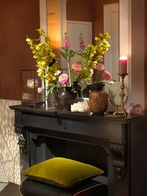 a table with vases of flowers and a mirror at City B&B Villa Nicola in Amsterdam