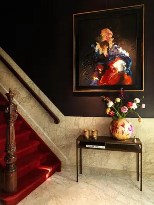 a painting of a woman on a wall next to a staircase at City B&B Villa Nicola in Amsterdam