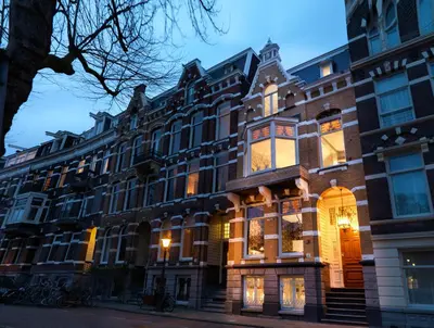 a large brick building on a city street at City B&B Villa Nicola in Amsterdam
