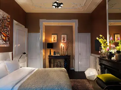 a bedroom with a large bed and a fireplace at City B&B Villa Nicola in Amsterdam