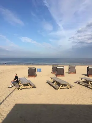 a man sitting on a picnic table on the beach at De Slotruine in Egmond aan den Hoef