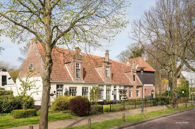 a large white house with a red roof at De Slotruine in Egmond aan den Hoef