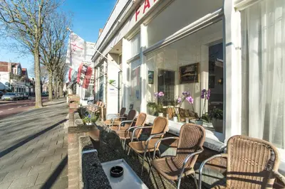 a row of chairs sitting outside of a store at Hotel Faber in Zandvoort
