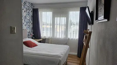 a small room with a bed and a window at Hotel Faber in Zandvoort