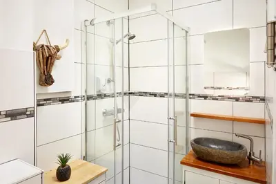 a bathroom with a glass shower and a sink at Guest House Aquarius in Zandvoort
