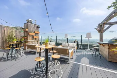 a deck with tables and chairs on top of a building at Leonardo Hotel Amsterdam Rembrandtpark in Amsterdam