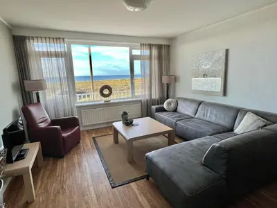 a living room with a couch and a chair at Appartementen Zeezicht in Katwijk aan Zee