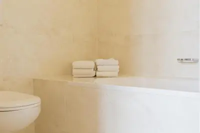 a bathroom with a toilet and a tub and towels at Appartementen Zeezicht in Katwijk aan Zee