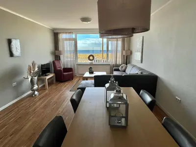 a living room with a table and a couch at Appartementen Zeezicht in Katwijk aan Zee
