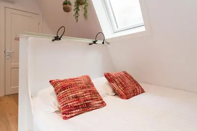 a white bed with two pillows on top of it at Saint Claire Studio's in Amsterdam