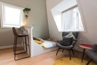 a living room with two chairs and a bed at Saint Claire Studio's in Amsterdam
