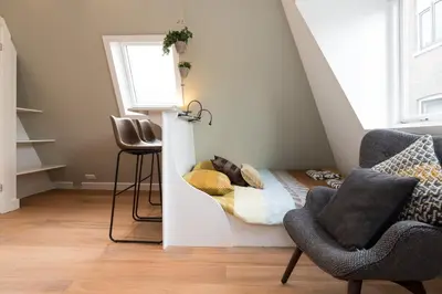 a room with a bed and a chair and a window at Saint Claire Studio's in Amsterdam