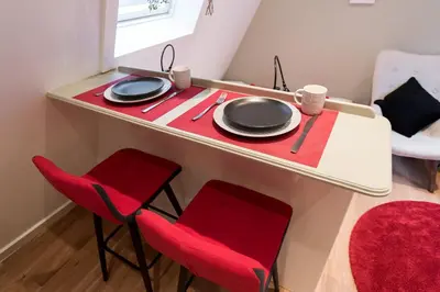 a table with red chairs and plates on it at Saint Claire Studio's in Amsterdam