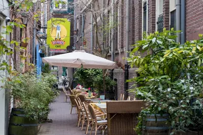 a table and chairs with an umbrella on a sidewalk at Saint Claire Studio's in Amsterdam