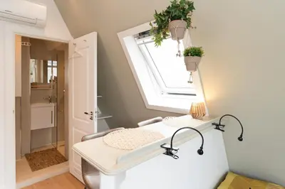 a bathroom with a white vanity and a window at Saint Claire Studio's in Amsterdam