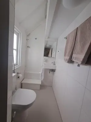 a white bathroom with a toilet and a sink at Edam, Garden Room with private entrance and rural view in Edam