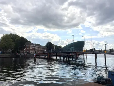 a dock with a boat sitting on top of the water at Newly renovated houseboat The Waterhouse in Amsterdam