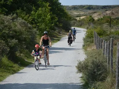 a group of people riding bikes down a road at Holiday Home in Noordwijkerhout near Lake in Noordwijkerhout