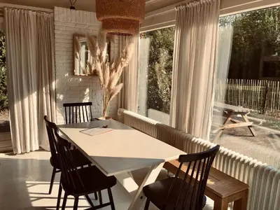 a dining room with a white table and chairs at Holiday Home in Noordwijkerhout near Lake in Noordwijkerhout