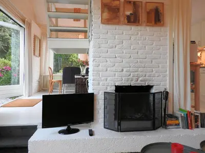 a living room with a tv and a fireplace at Holiday Home in Noordwijkerhout near Lake in Noordwijkerhout