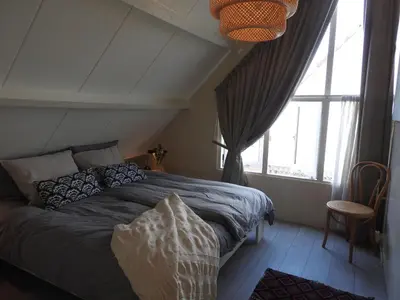 a bedroom with a bed and a large window at Holiday Home in Noordwijkerhout near Lake in Noordwijkerhout