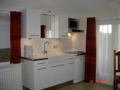 a kitchen with white cabinets and a sink at Studio Zandvoort in Zandvoort