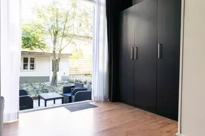 a hallway with black cabinets and a large window at Frankendael Apartments in Amsterdam