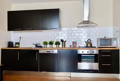 a kitchen with black cabinets and a stove at Frankendael Apartments in Amsterdam