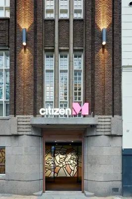 a building with two pink signs on top of it at citizenM Amstel Amsterdam in Amsterdam