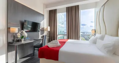 a hotel room with a bed and a large window at PLAZA Premium Almere in Almere