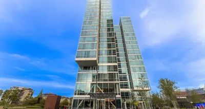 a tall glass building with a blue sky in the background at PLAZA Premium Almere in Almere