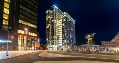 a city street with tall buildings at night at PLAZA Premium Almere in Almere