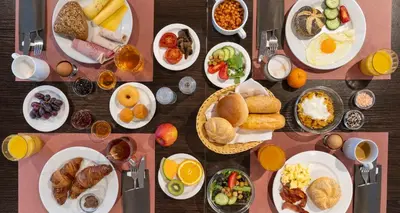 a table with many plates of breakfast food on it at PLAZA Premium Almere in Almere