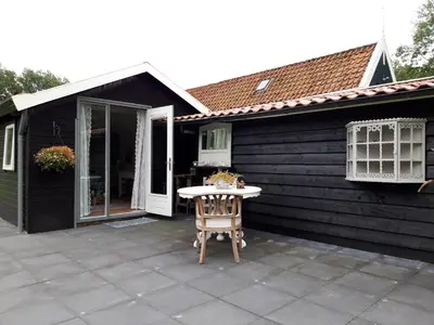 a patio with a table in front of a house at Rietzicht in Alkmaar