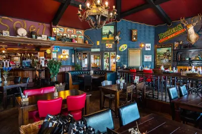 a restaurant with tables and chairs and a bar at EuroParcs Parc du Soleil in Noordwijk aan Zee