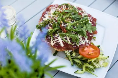 a plate of food with a salad on a table at EuroParcs Parc du Soleil in Noordwijk aan Zee