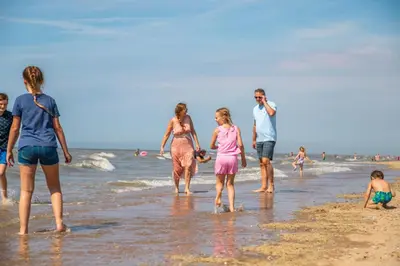 a group of people walking on the beach at EuroParcs Parc du Soleil in Noordwijk aan Zee
