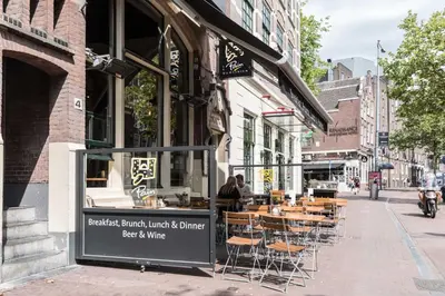 a cafe on a city street with tables and chairs at Anny's Warehouse City Centre! in Amsterdam