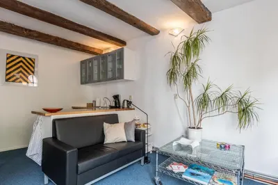a living room with a black leather couch and a table at Anny's Warehouse City Centre! in Amsterdam