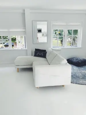 a white living room with a white couch and windows at ECHT-Bergen in Bergen