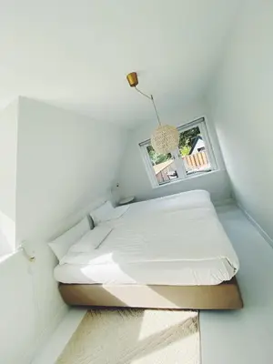 a small bedroom with a bed and a window at ECHT-Bergen in Bergen