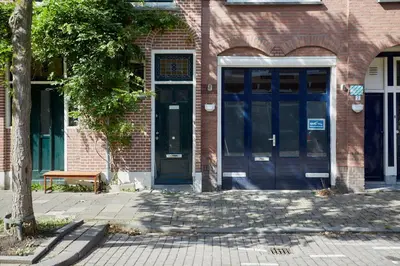 a brick building with blue doors and a bench in front at B&B Muntzicht in Utrecht
