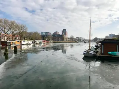 a boat is docked in the water in a river at B&B Muntzicht in Utrecht