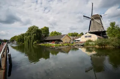 a windmill next to a river with a mill at B&B Muntzicht in Utrecht