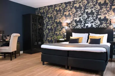 a bedroom with a bed with a black and white wallpaper at Grand Canal Boutique Hotel in Amsterdam
