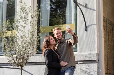 a man and a woman taking a picture with a cell phone at Grand Canal Boutique Hotel in Amsterdam