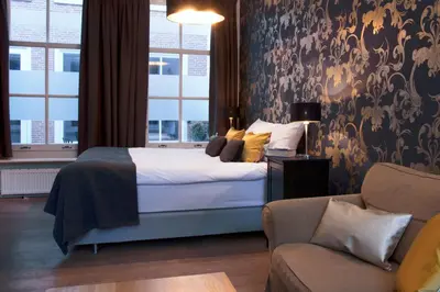 a bedroom with a bed and a couch at Grand Canal Boutique Hotel in Amsterdam