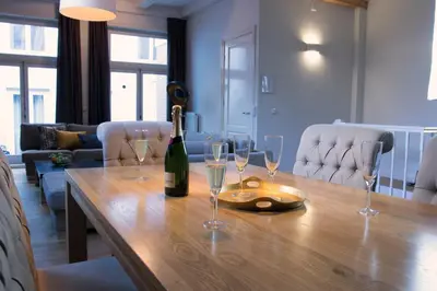 a bottle of wine sitting on a wooden table with wine glasses at Grand Canal Boutique Hotel in Amsterdam