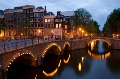 a bridge over a river in a city at night at Grand Canal Boutique Hotel in Amsterdam